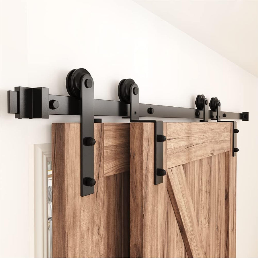 Barn door hardware system with wooden sliding doors on a white wall.