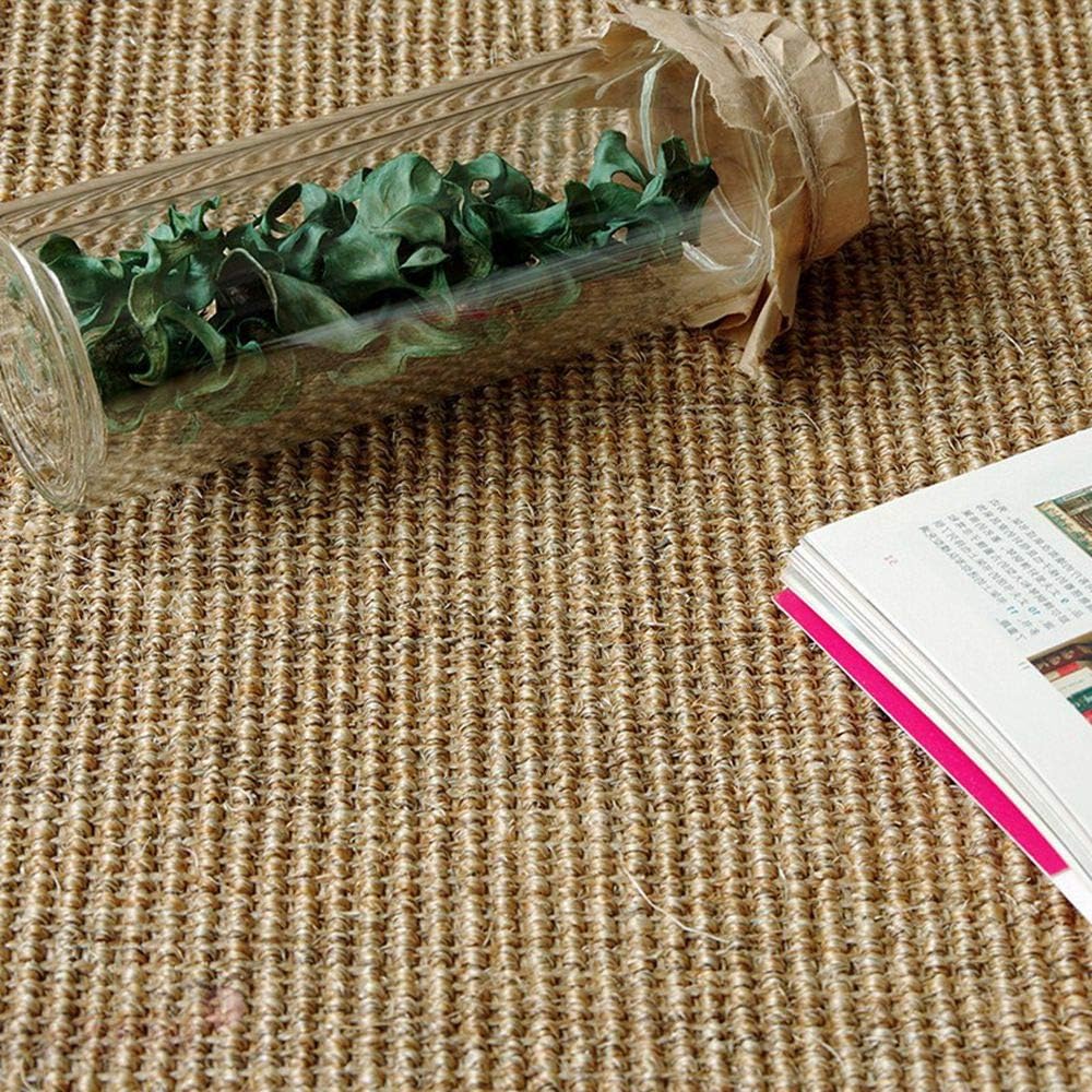 Glass bottle with green leaves on a textured surface next to an open book