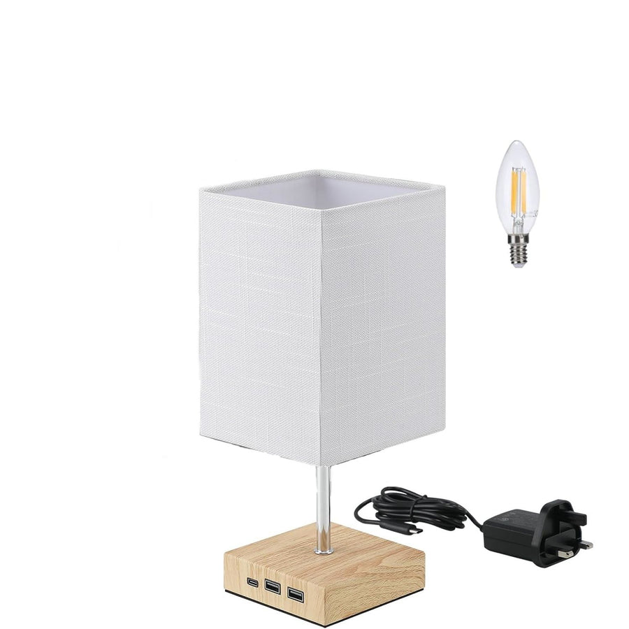 Table lamp with wooden base, white fabric shade, and USB ports on a white background