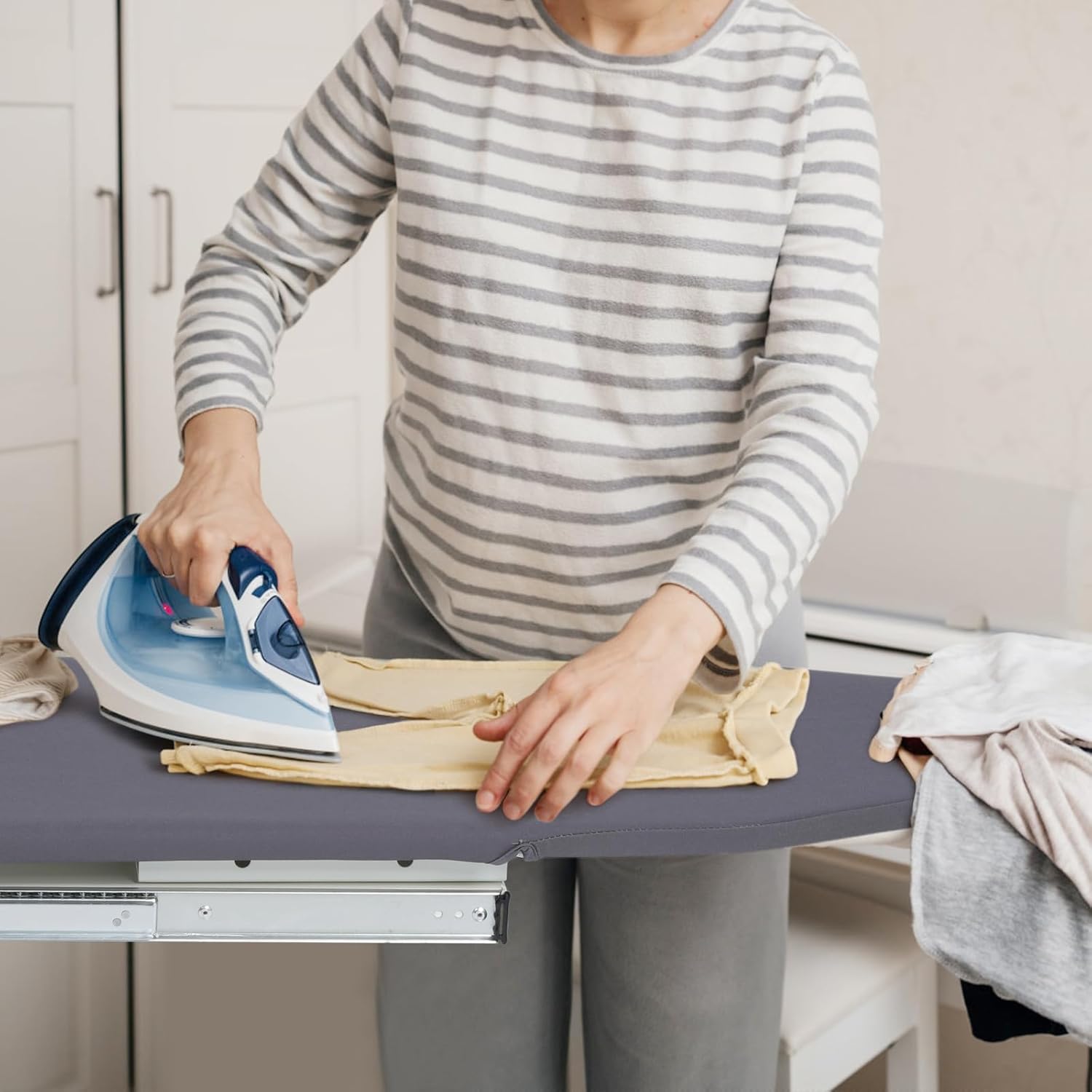 Person ironing clothes on a table with an iron in a home setting