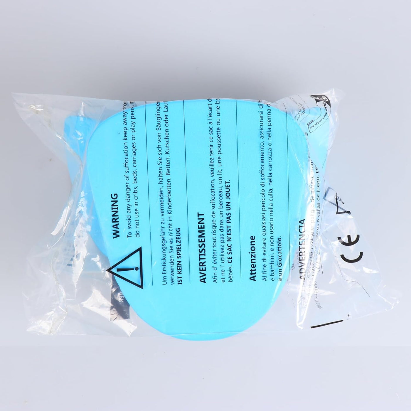 Turquoise eye patch with warning labels in a clear plastic package on a light gray background