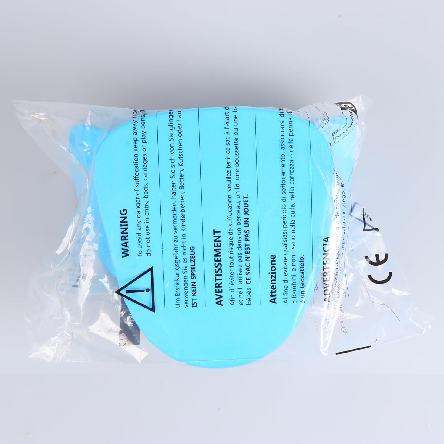 Turquoise eye patch with warning labels in a clear plastic package on a light gray background