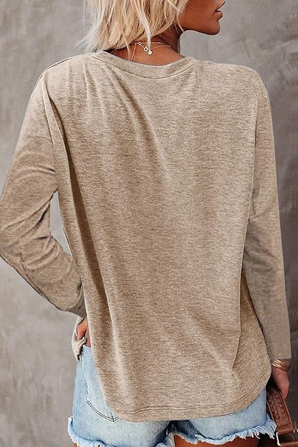 Person wearing a beige long-sleeve top and denim jeans against a gray background