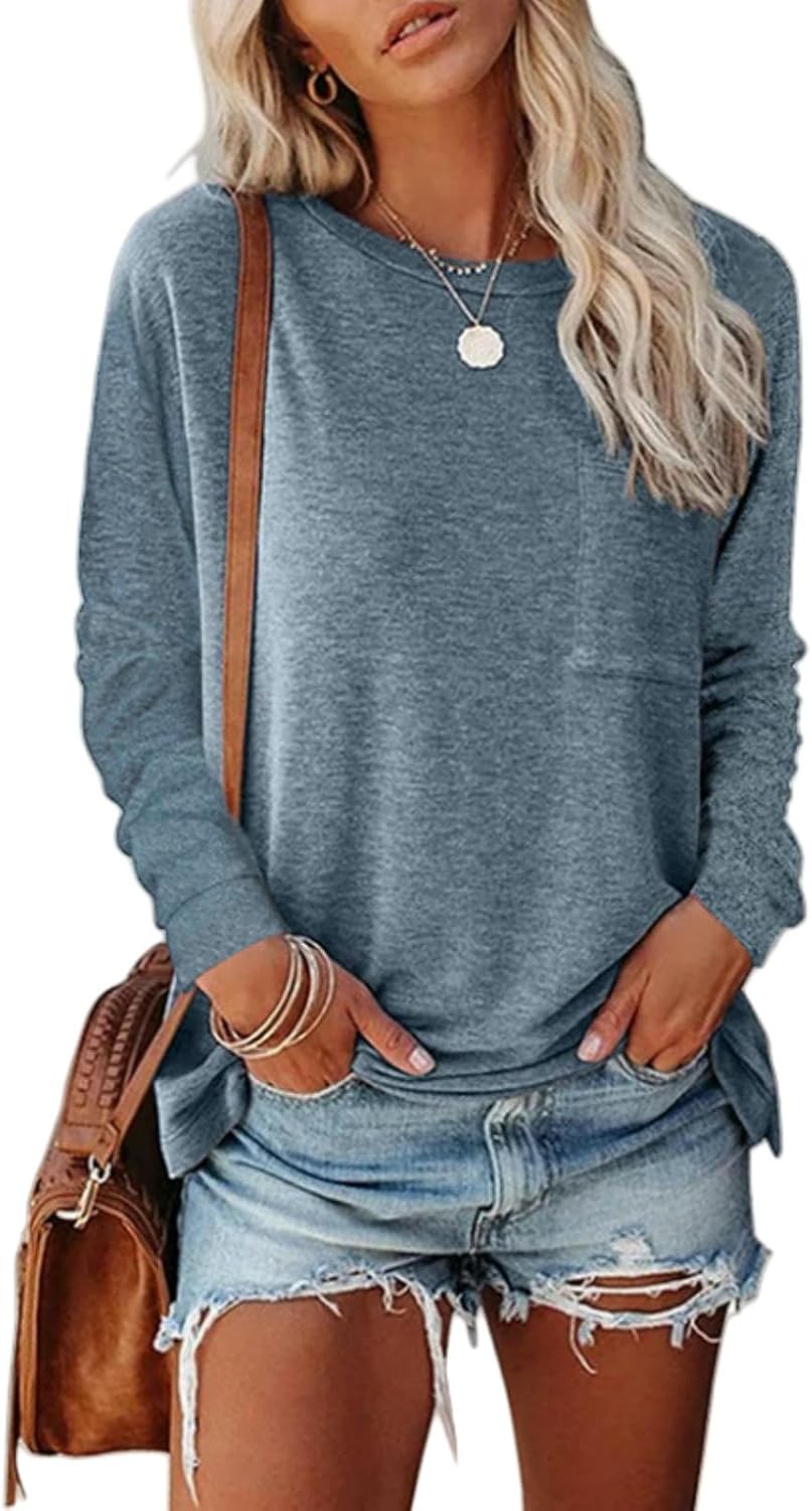Woman wearing a blue sweater and denim shorts with a brown leather bag.