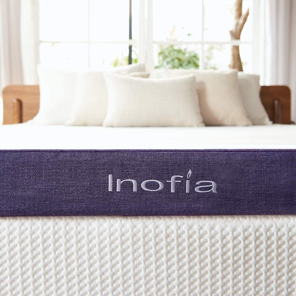 Inofia mattress with pillows and a wooden headboard in a bright room.