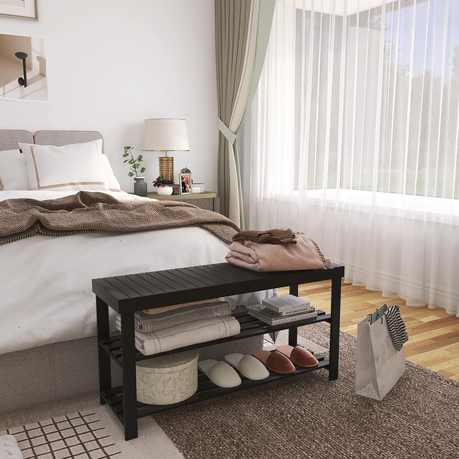 Black wooden bench in a bedroom with shoes and folded clothes on it