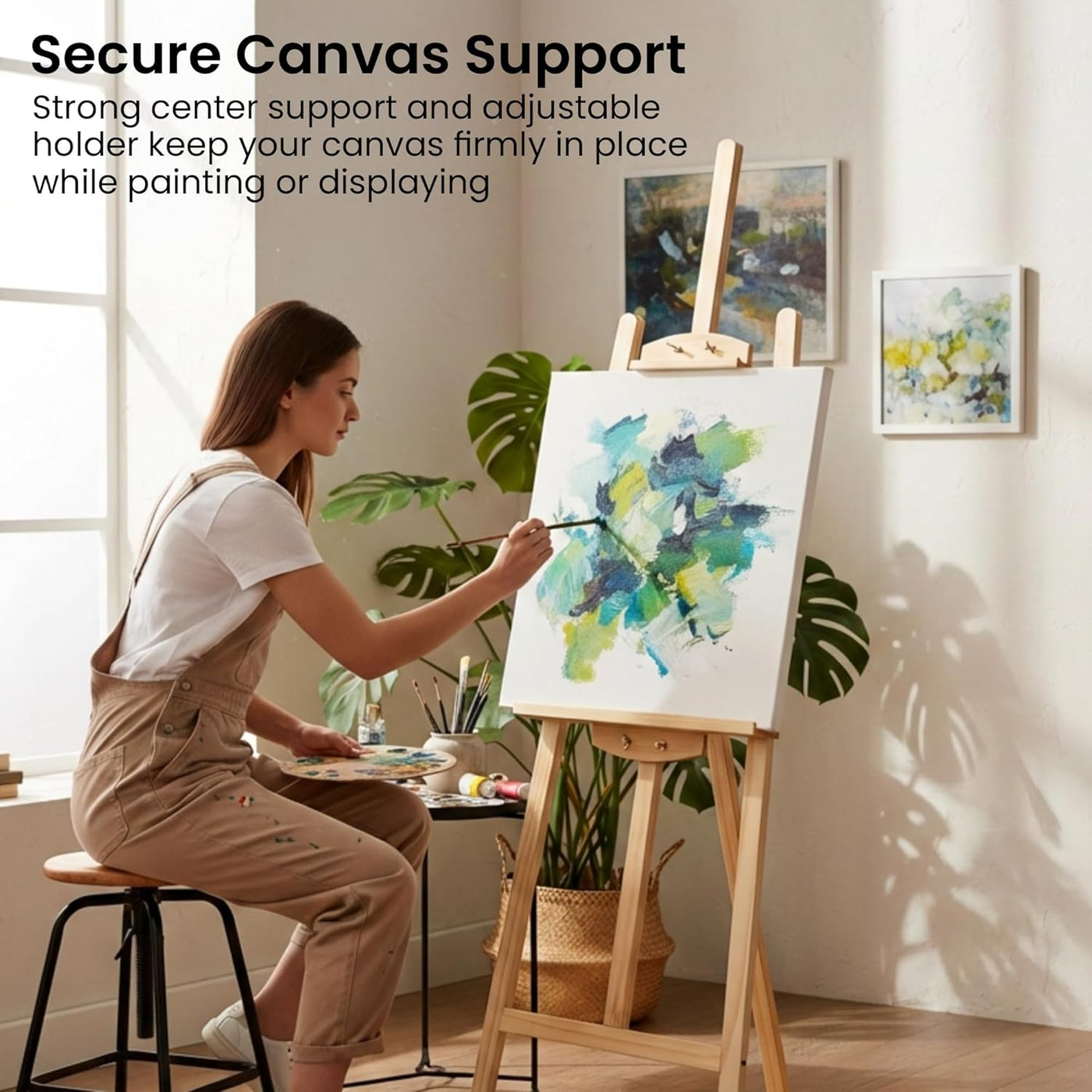 Woman painting on a canvas supported by an easel in a bright room with plants.
