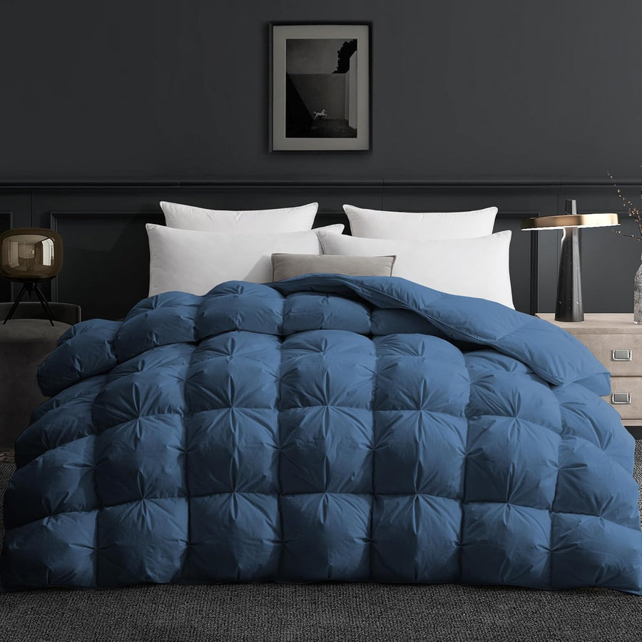 Blue quilted comforter on a bed in a dark bedroom setting