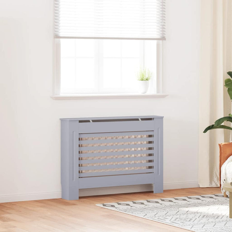 Gray radiator in a room with a window and plant