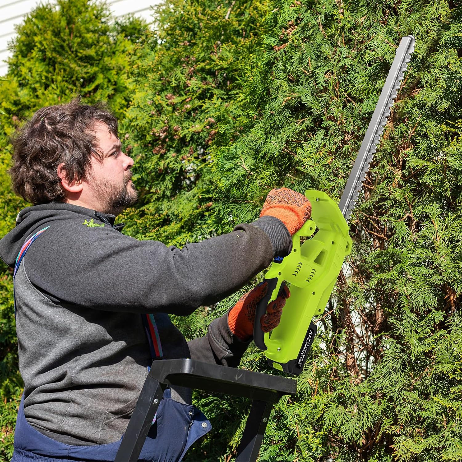 Person using a green chainsaw to trim trees