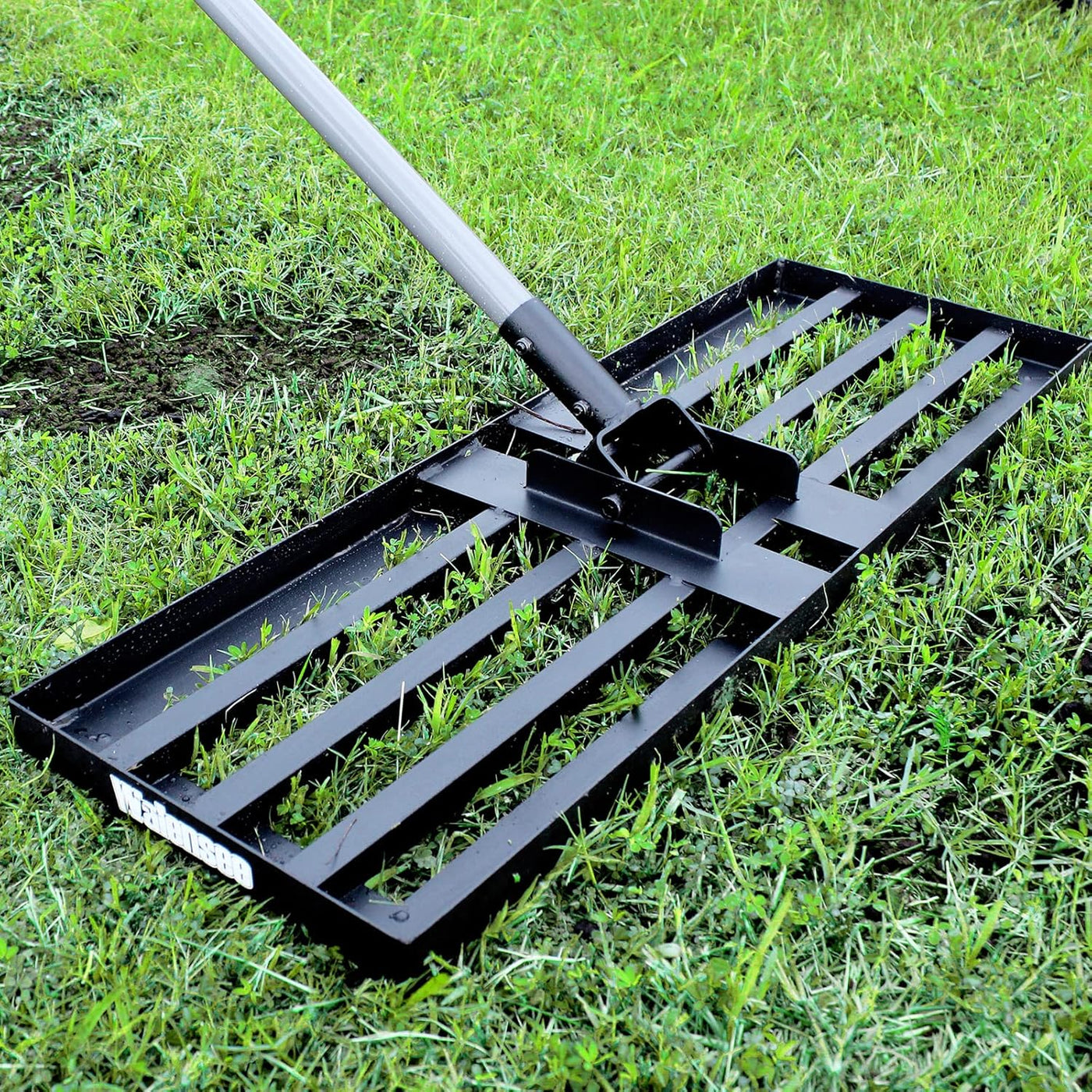 Black lawn rake on grass