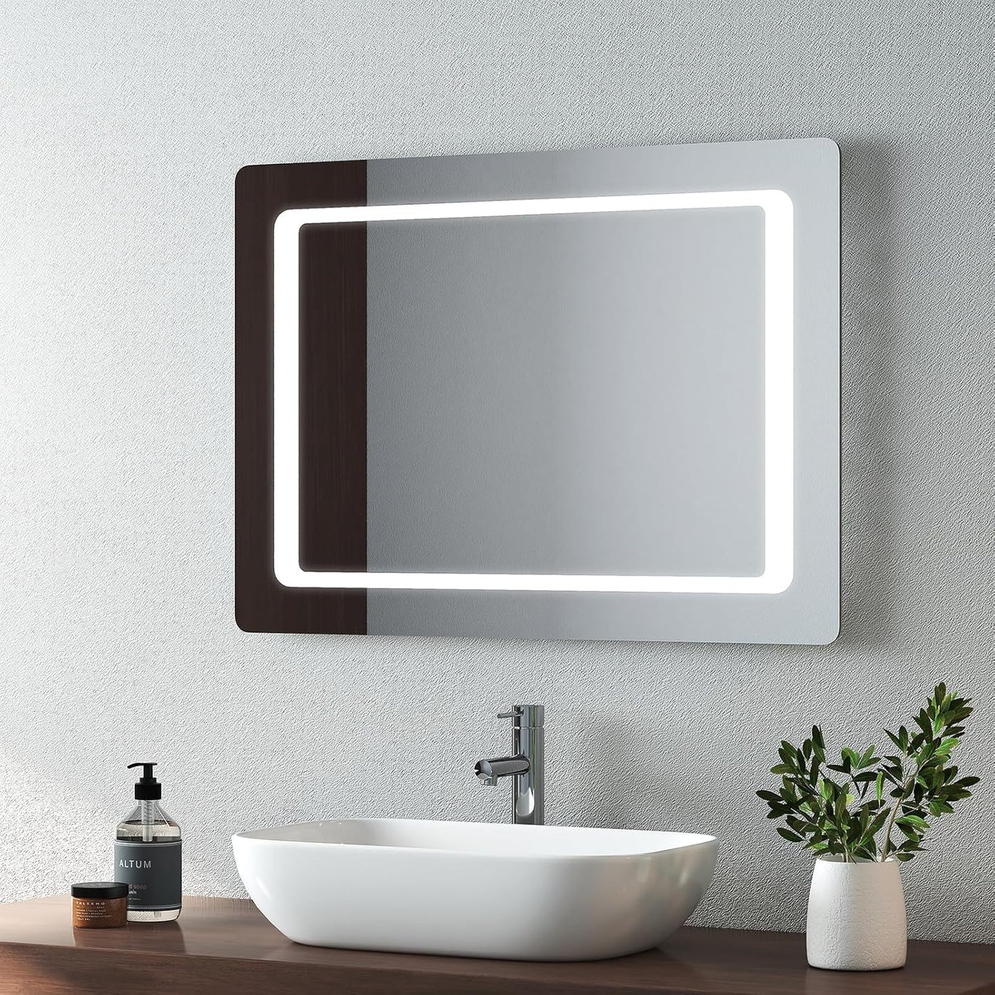 Bathroom setup with a illuminated mirror, sink, and decorative elements.