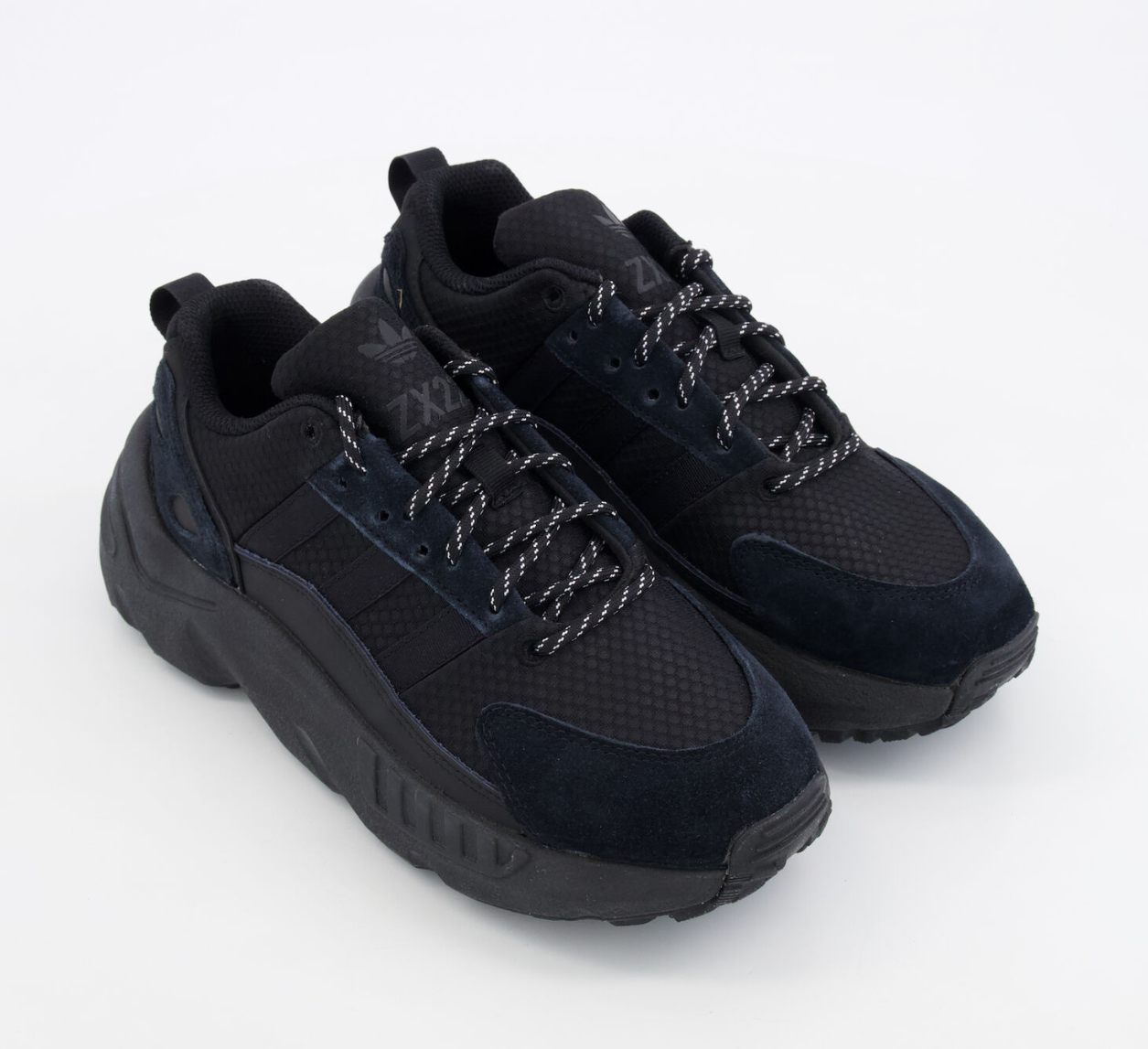 Black sneakers with textured sole on a white background