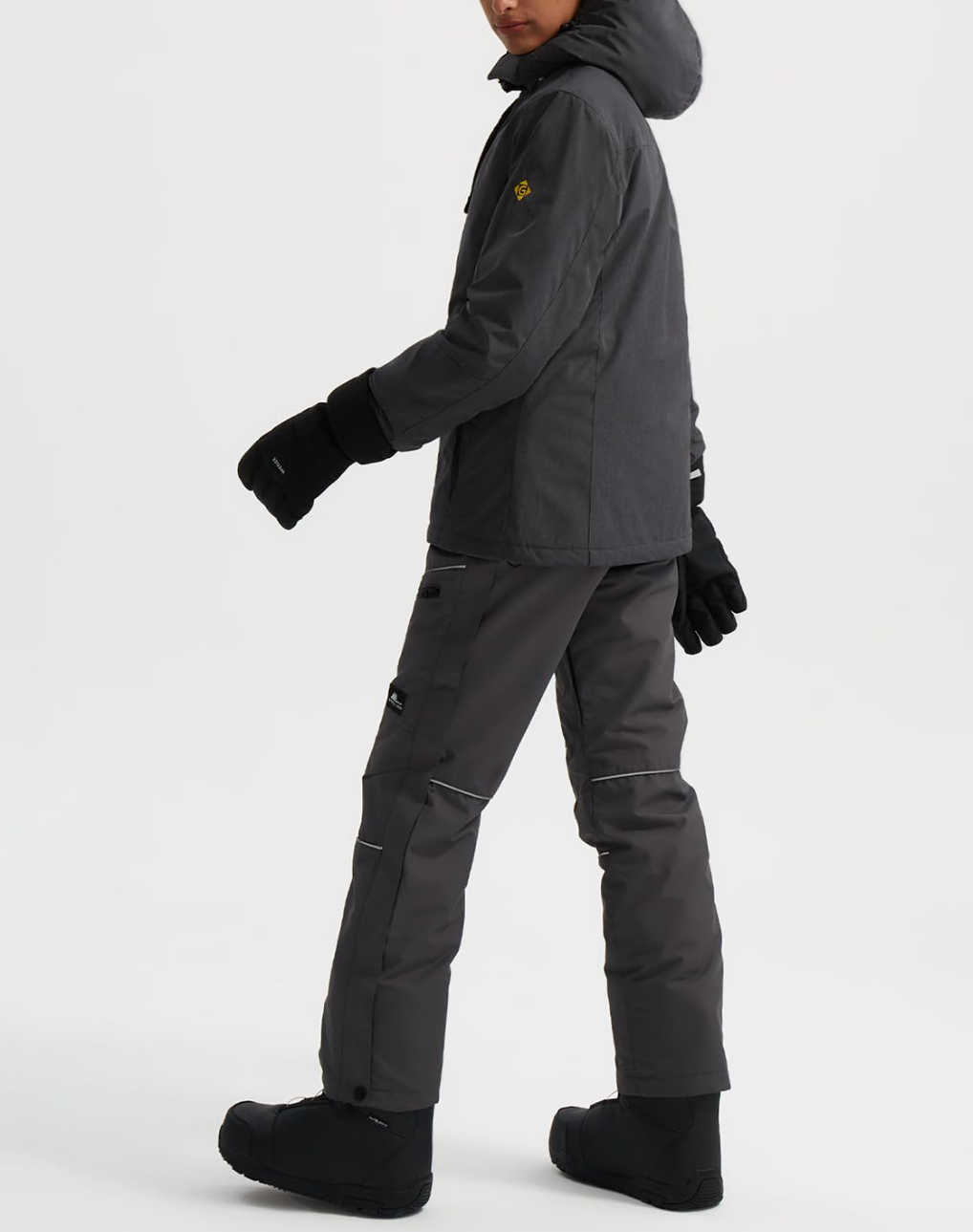 Person wearing a dark gray snowsuit on a white background