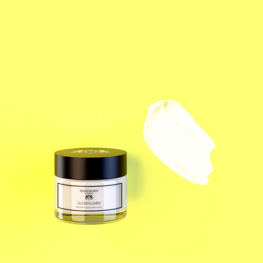 Jar of skincare product with a swatch of cream on a yellow background