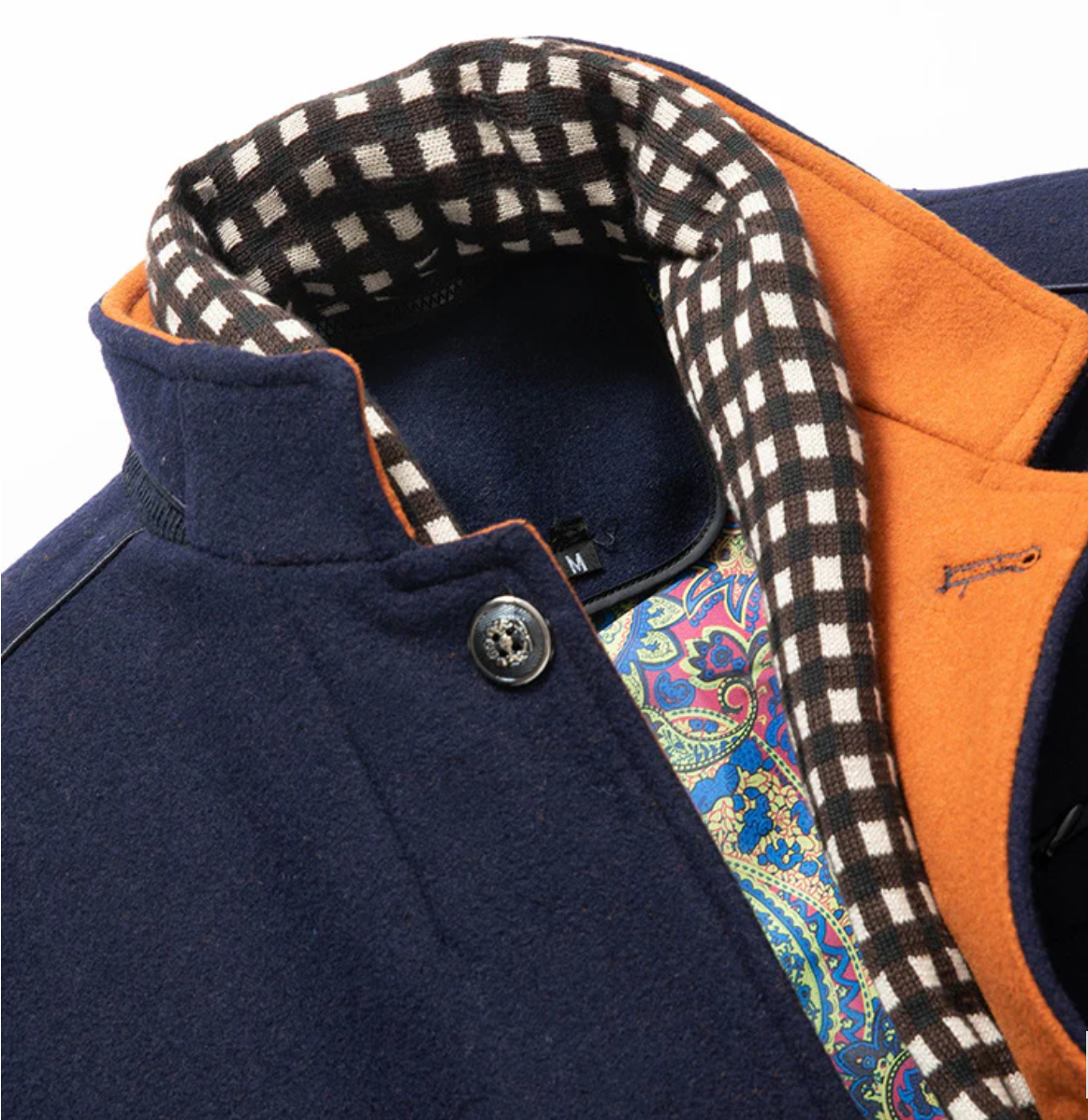 Close-up of a jacket with a checkered interior, orange lining, and patterned fabric inside.