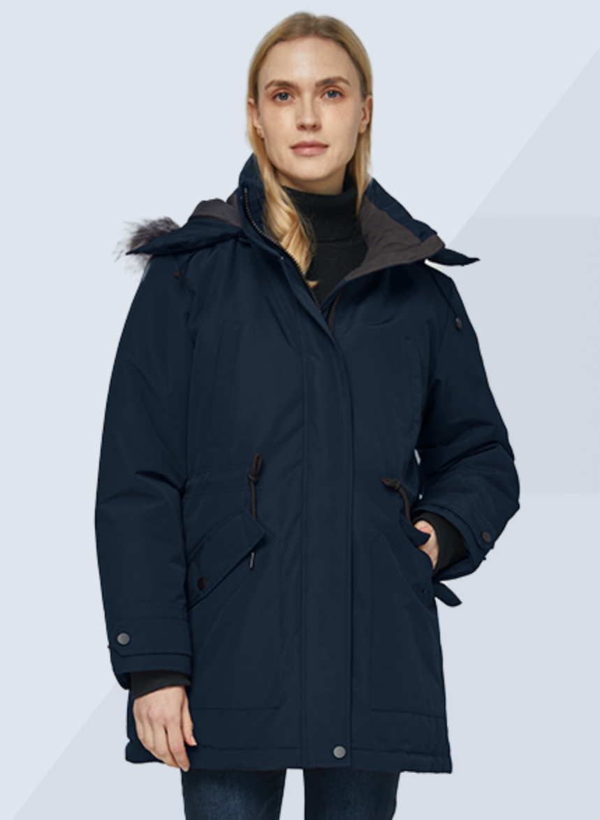 Woman wearing a dark blue coat with a hood on a light gray background