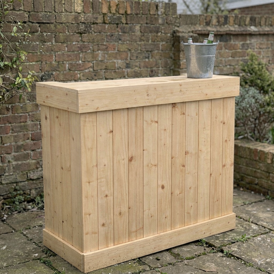 Wooden outdoor bar with a metal bucket on top against a brick wall.