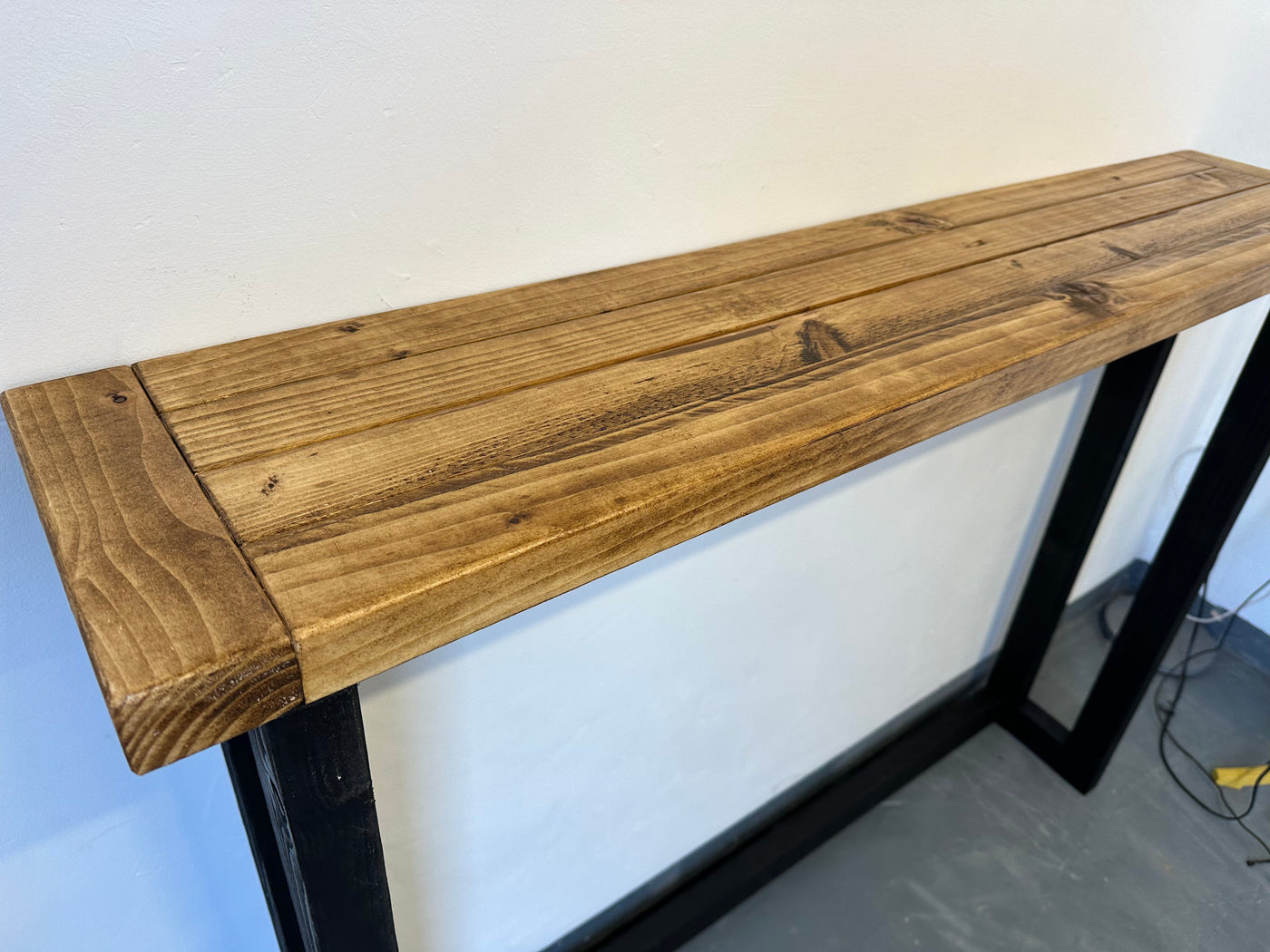 Wooden table with black metal legs on a white background