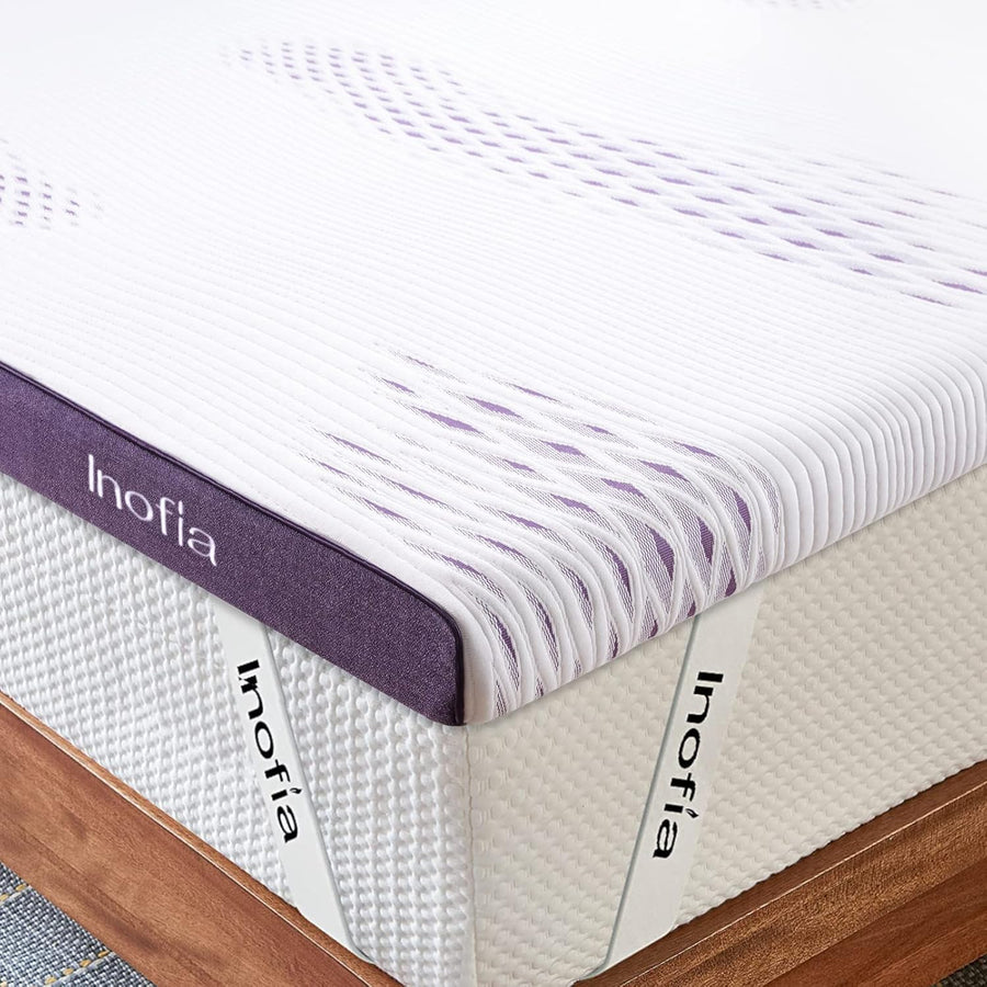 Inofia mattress with a striped cover on a wooden bed frame.