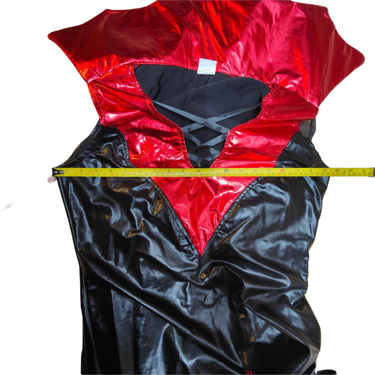 Red and black jacket with a measuring tape for size reference on a white background