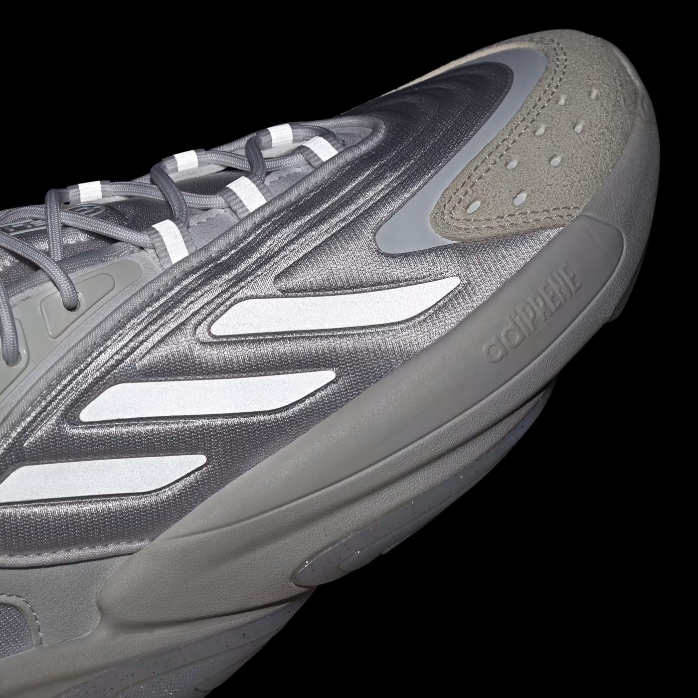Gray athletic shoe with brand logo on a black background