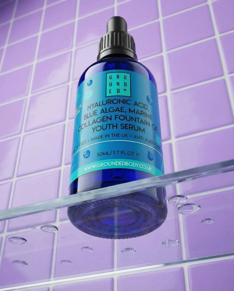 Blue serum bottle with dropper on a purple tiled background