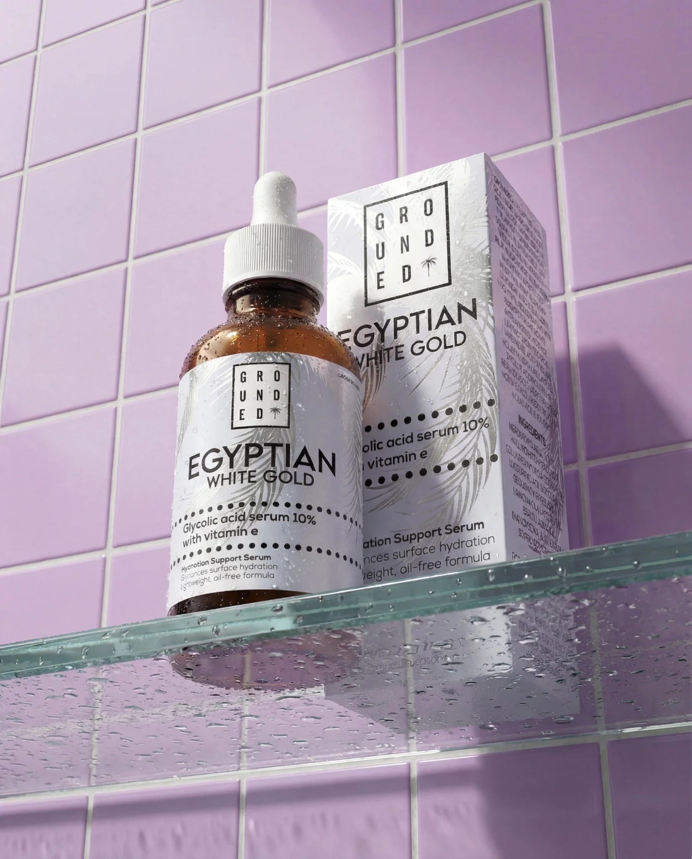 Grounded Egyptian White Gold skincare serum bottle and packaging on a purple tiled shelf.