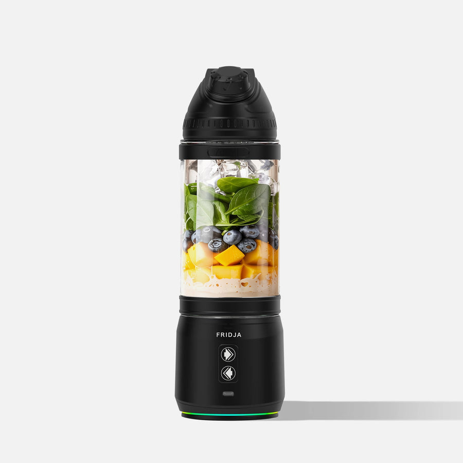 Black portable blender with ingredients inside on a white background