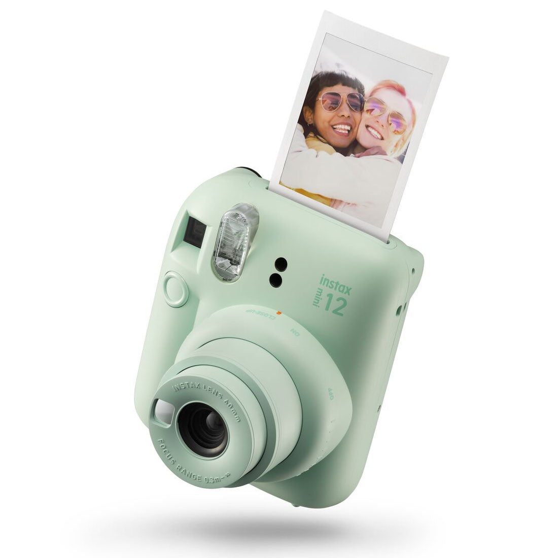 Mint green instant camera with a printed photo on a white background