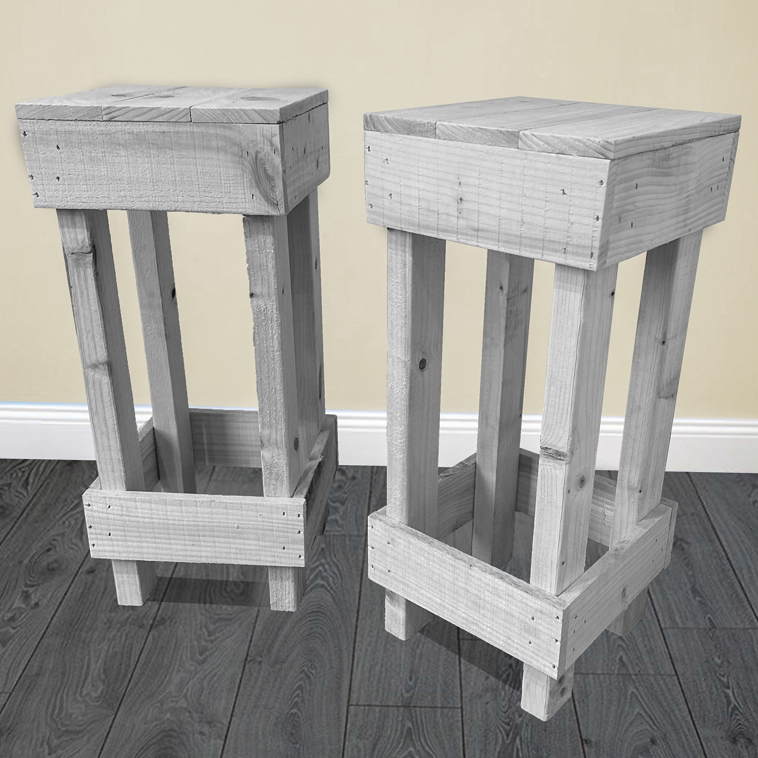 Two wooden stools with a grayish finish on a dark wooden floor.