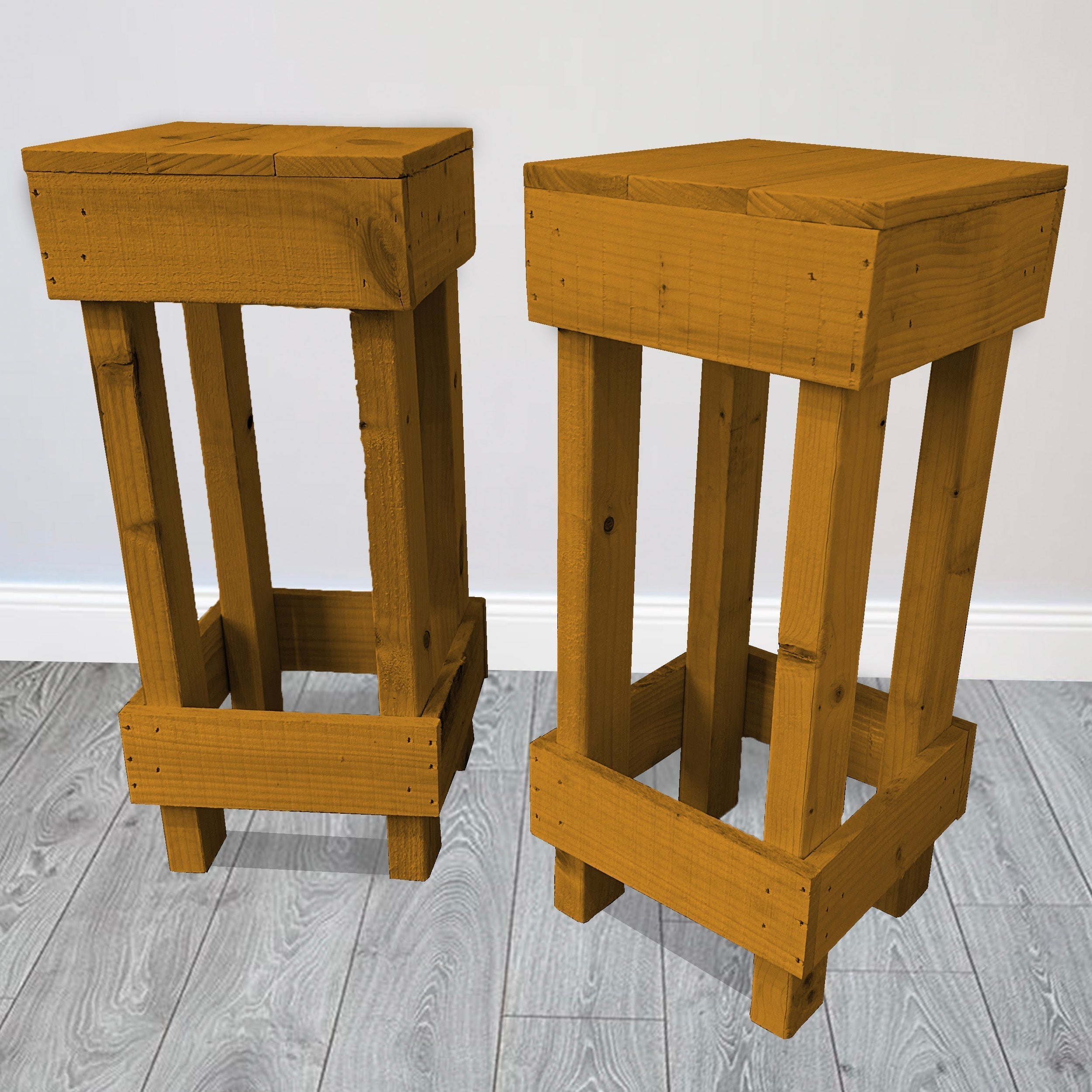 Two wooden stools on a gray wooden floor with a white wall background