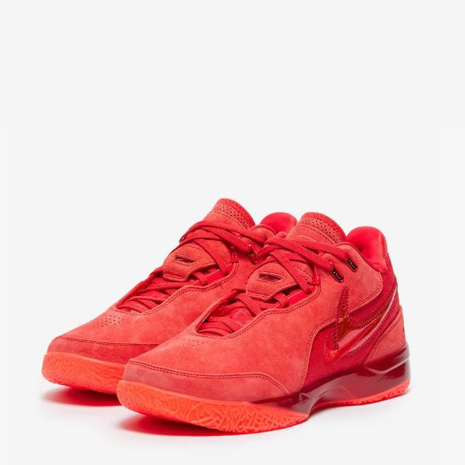 A pair of red Nike LeBron NXXT Gen AMPD basketball shoes on a white background.