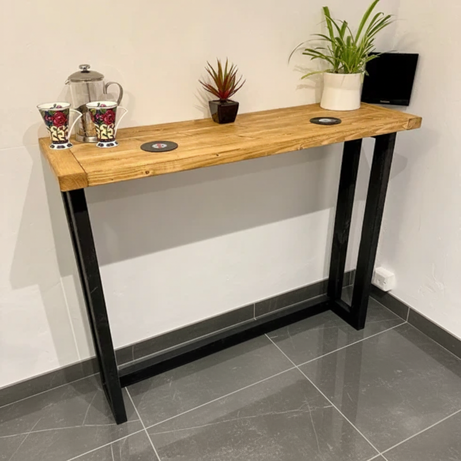 Wooden console table with black legs against a white wall.