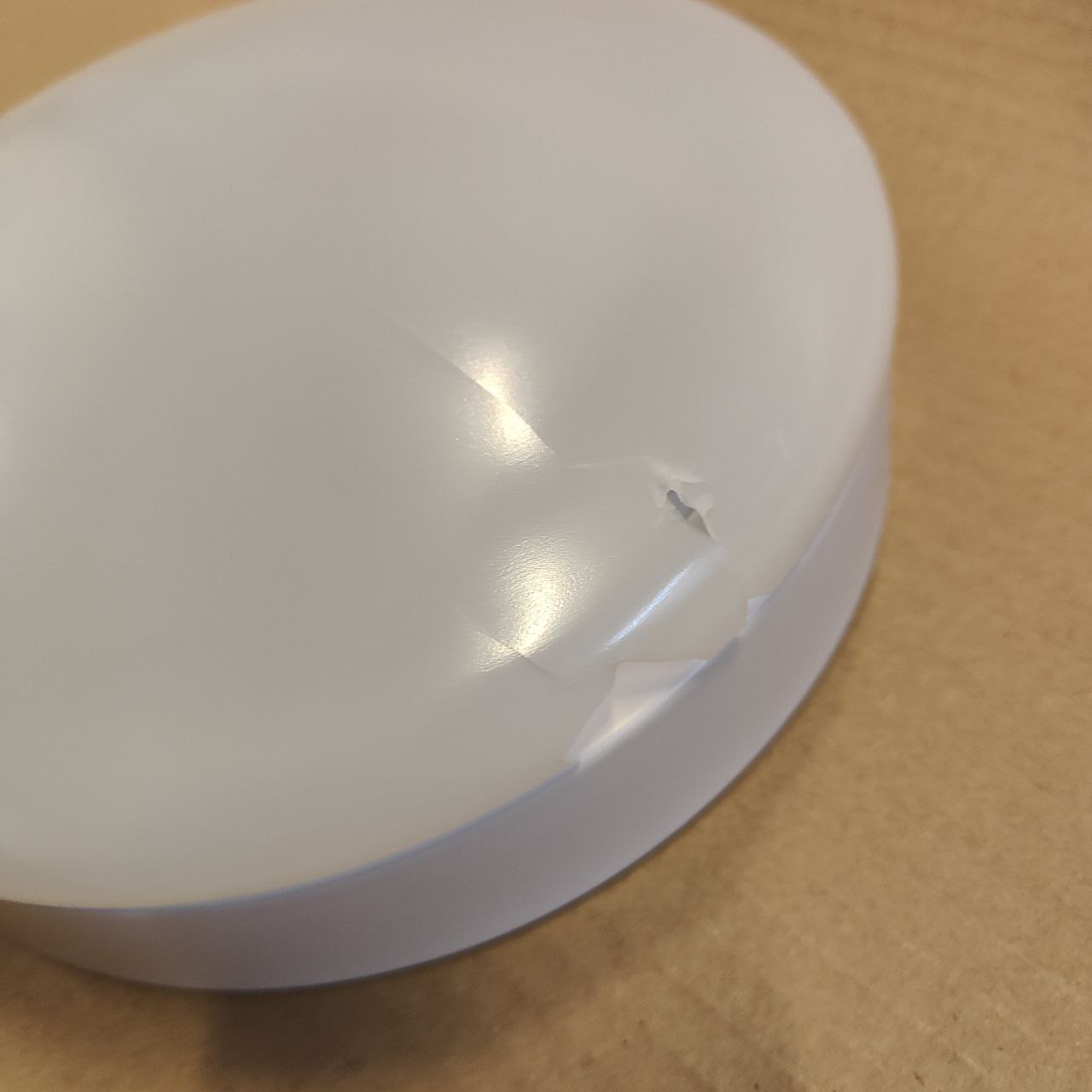 White plastic object on a beige surface