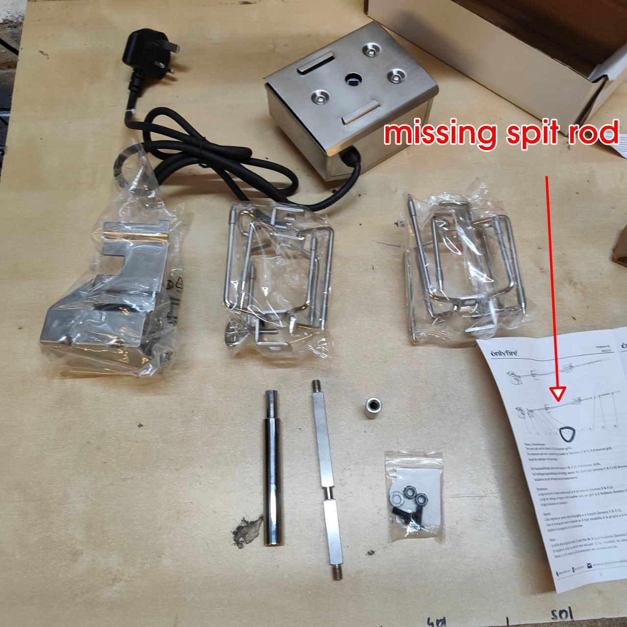 Electrical components and parts on a wooden surface with a missing part indicated.