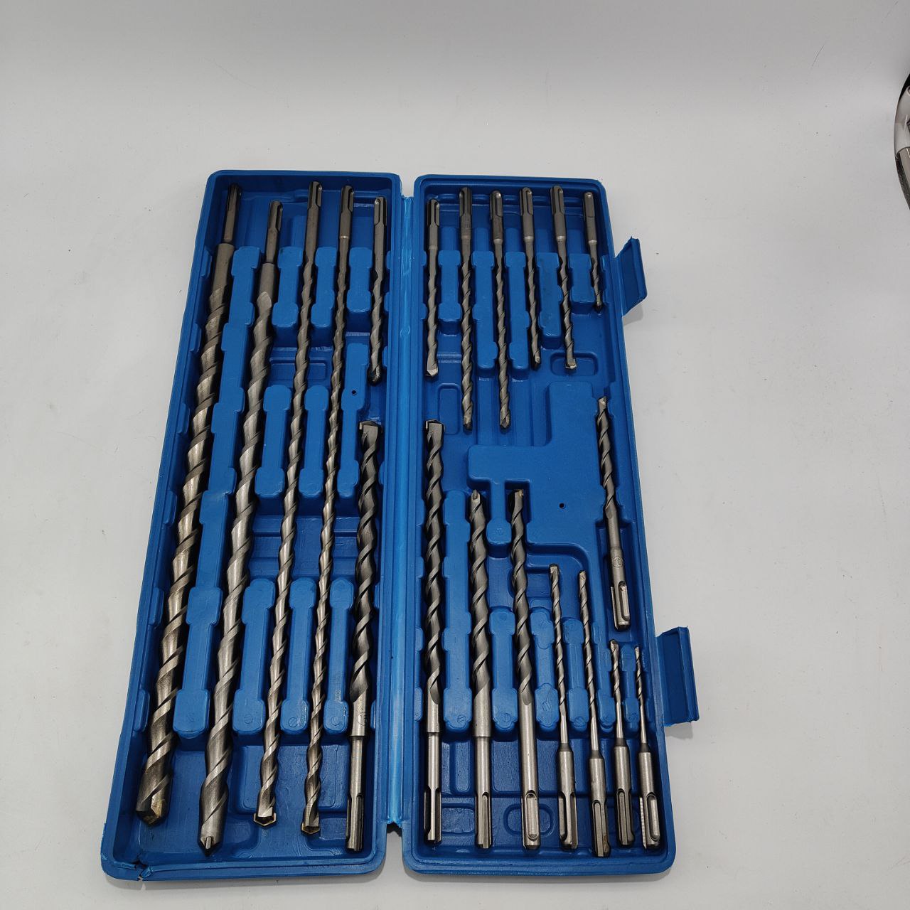 Set of drill bits in a blue case on a white background