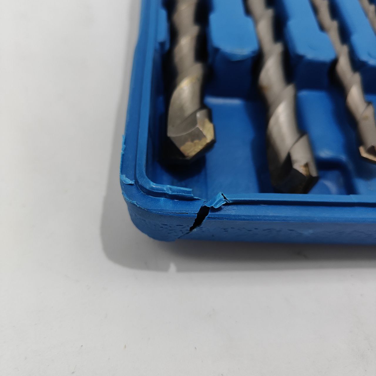 Set of drill bits in a blue case on a white background