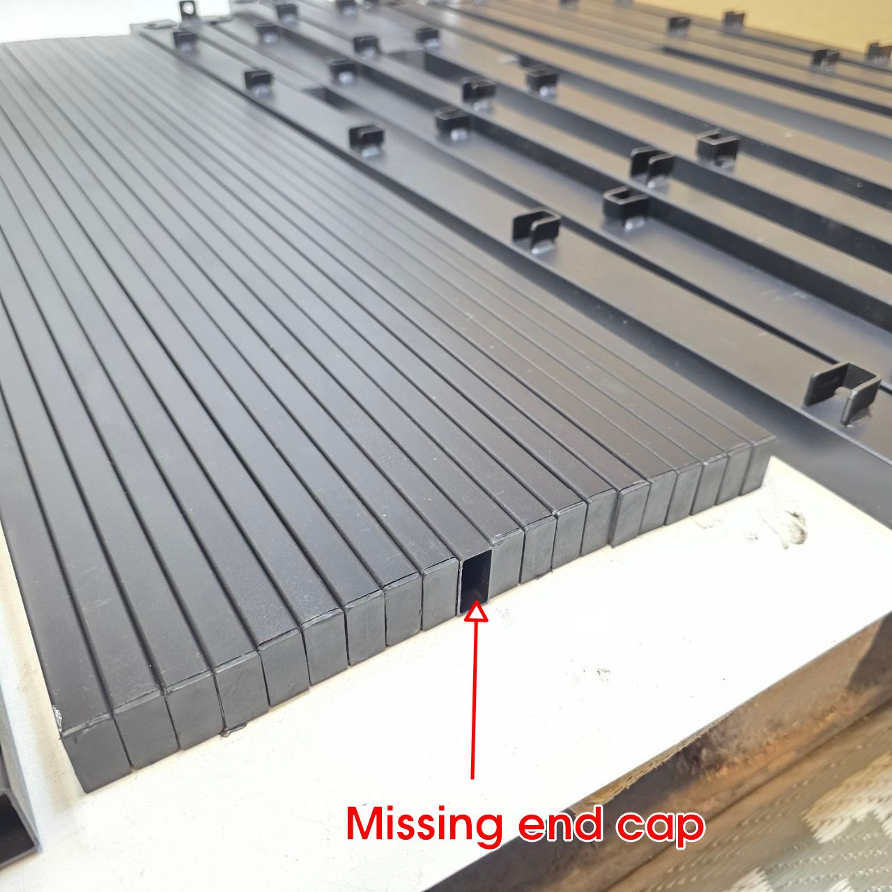 Metallic grid structure with a missing end cap indicated by text and arrow
