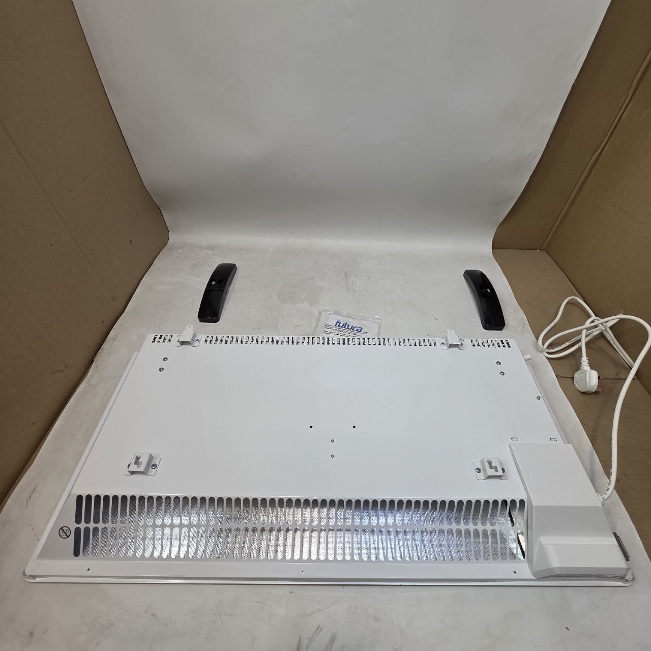 White electronic device with a cable on a cardboard surface