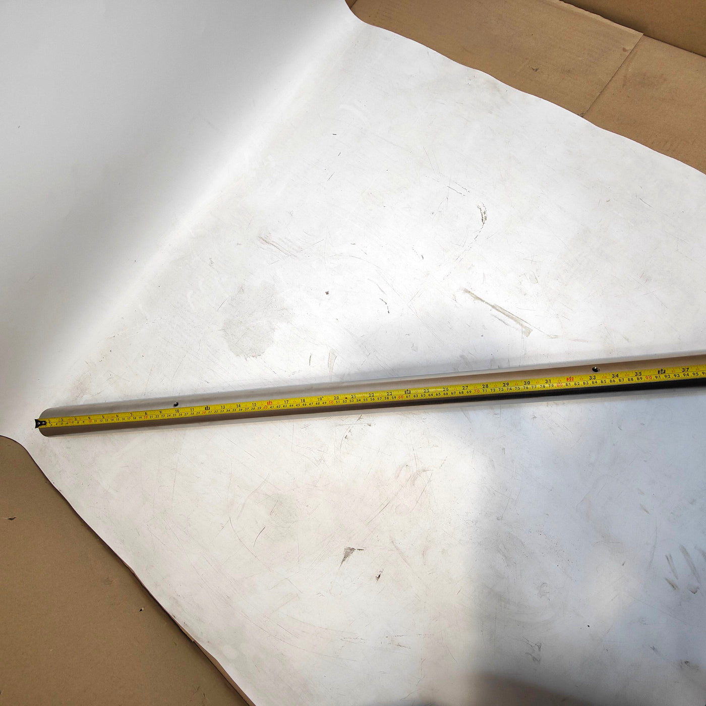 Tape measure on a white surface with cardboard edges