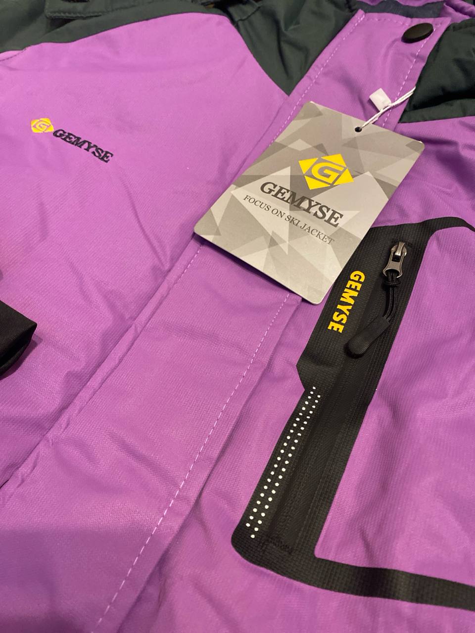 Purple jacket with a Gemyse tag on a black background