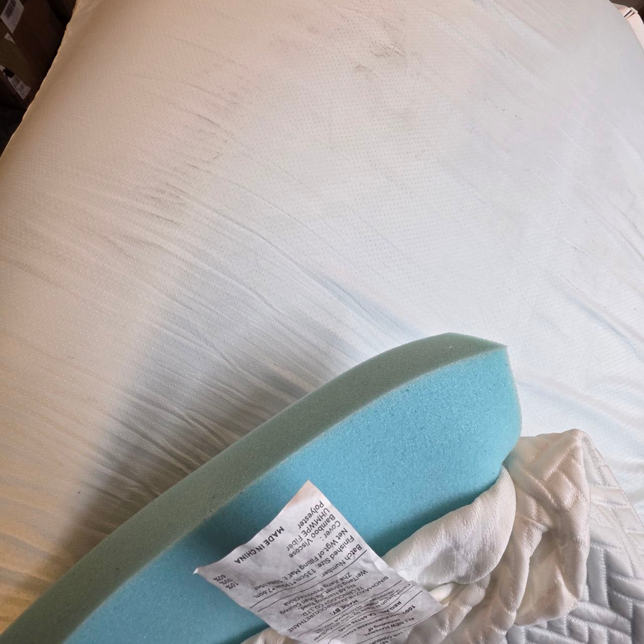 Blue foam block on a mattress with a piece of paper underneath