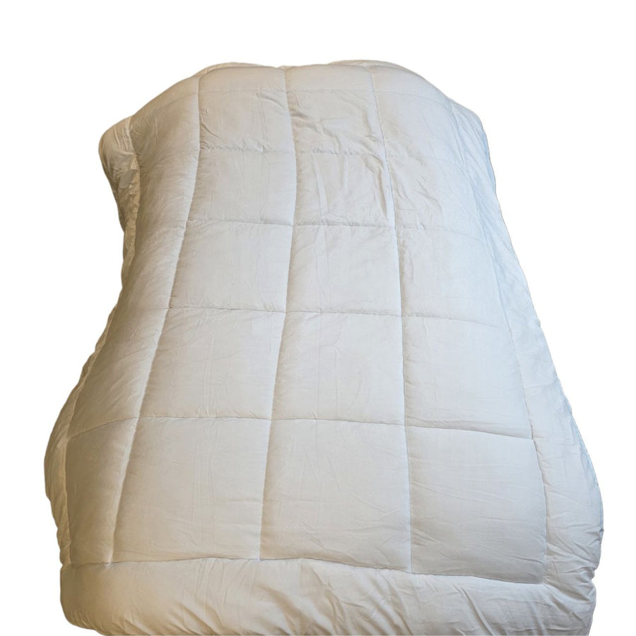 Beige quilted coverlet on a white background