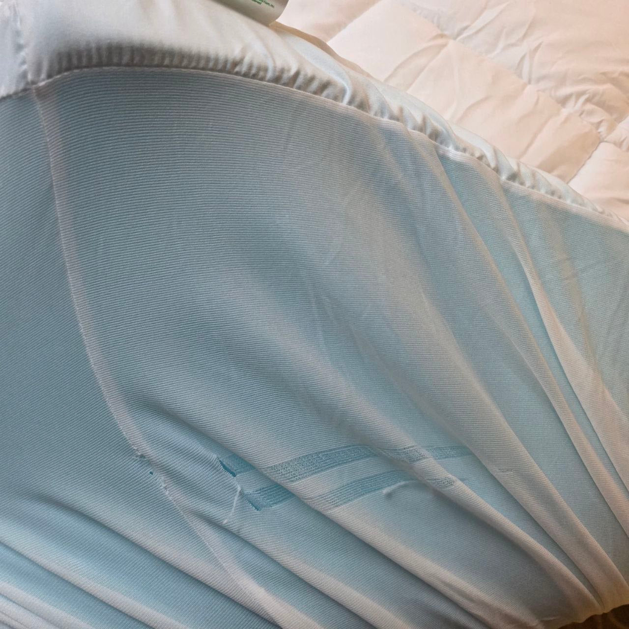 Close-up of a light blue fabric with a textured pattern on a beige surface.