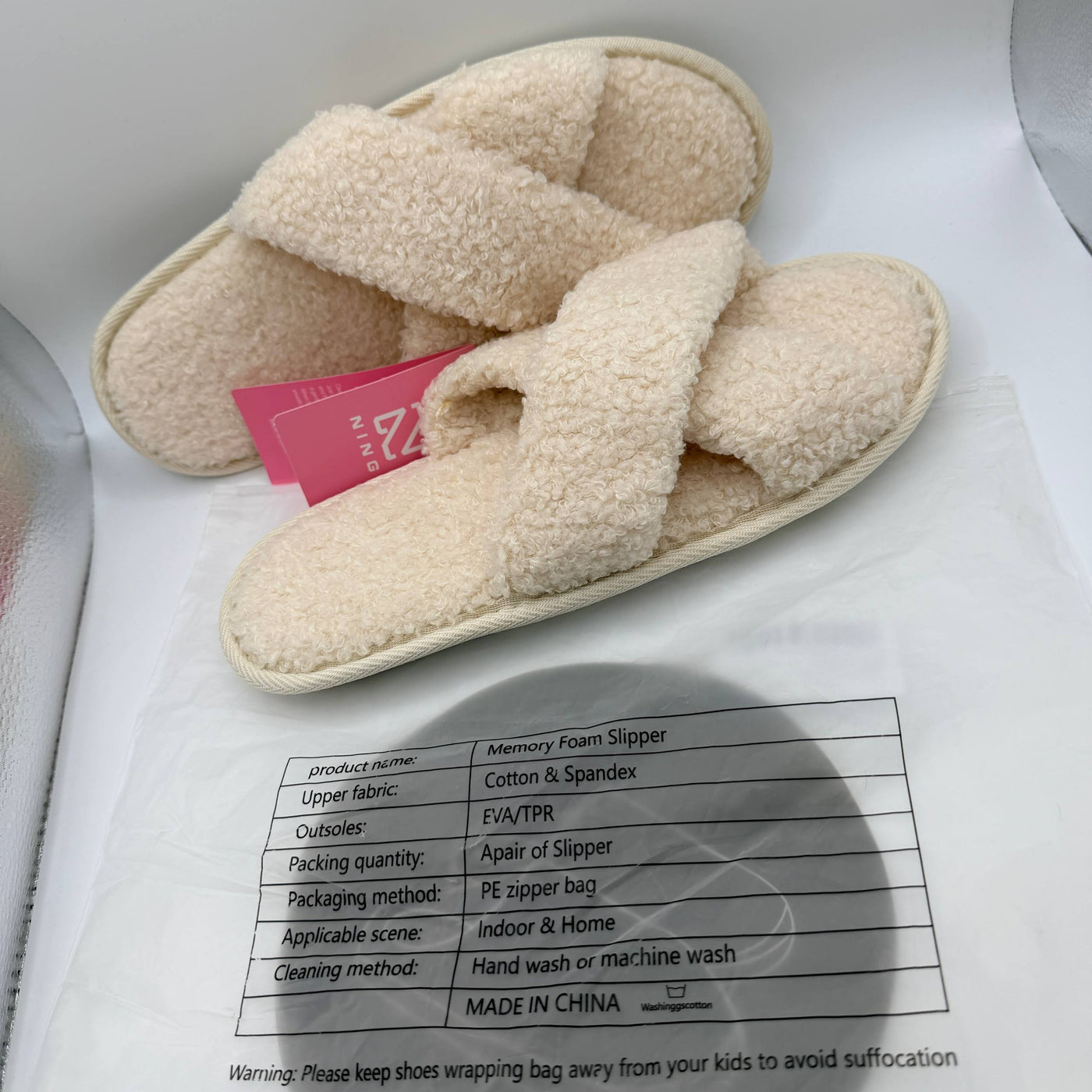 Beige slippers with a label on a white background