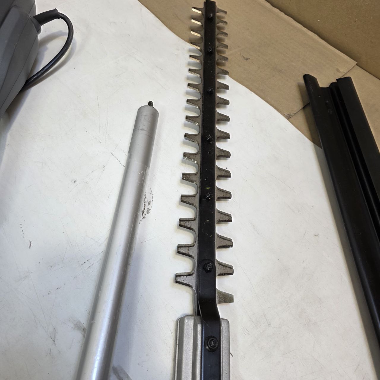 Garden pruner with a long handle on a white surface
