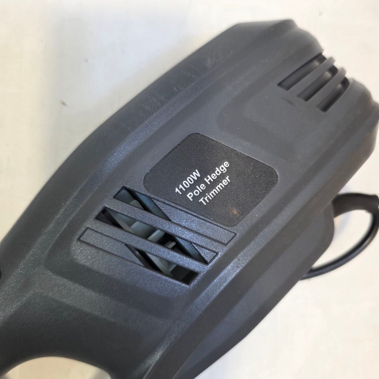 Black pole hedge trimmer with '1100W Pole Hedge Trimmer' label on a white background