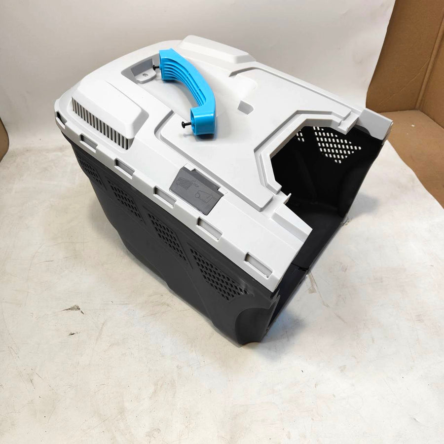 Black and white electronic device with blue handle on a light gray surface