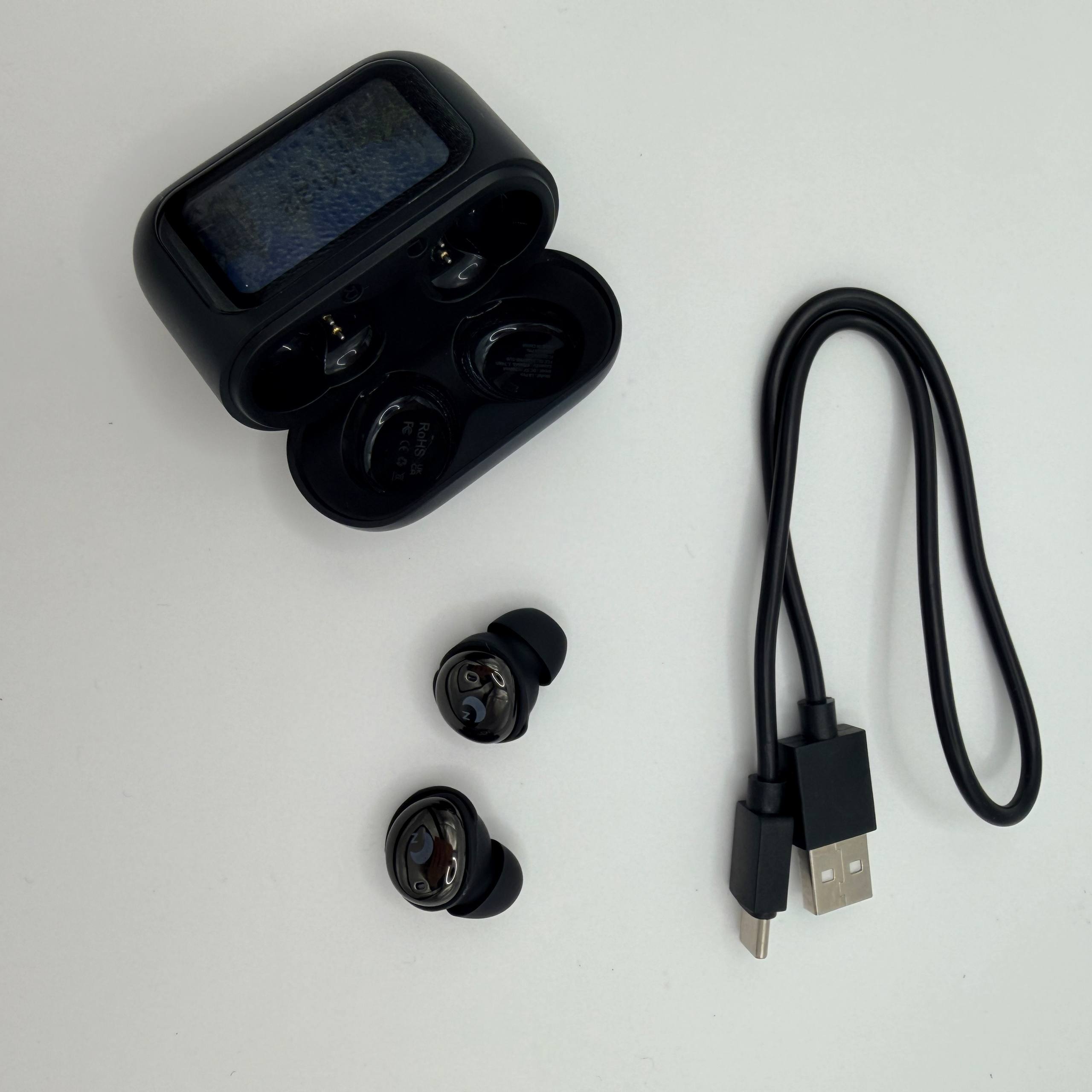 Black wireless earbuds with charging case and USB cable on a white background